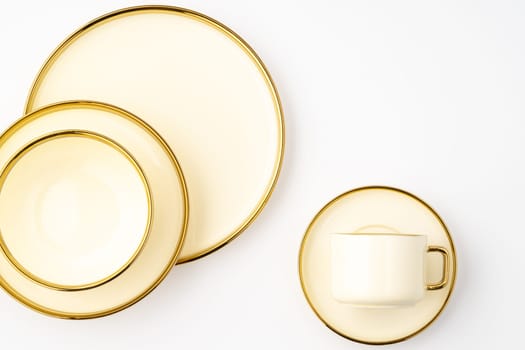 A top-view shot of golden luxury ceramic kitchen utensils on a white background