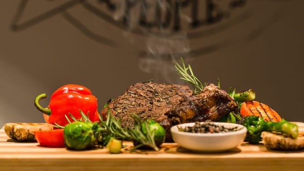 Closeup of serving table for lunch, fried meat, vegetables, green pepper and grilled potatoes on wooden board