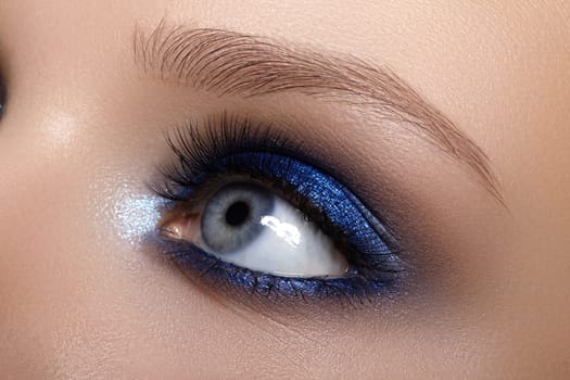 Closeup Macro of Woman Face with Blue Eyes Make-up. Fashion Celebrate Makeup, Glowy Clean Skin, perfect Shapes of Brows. Shiny Simmer and Rouge