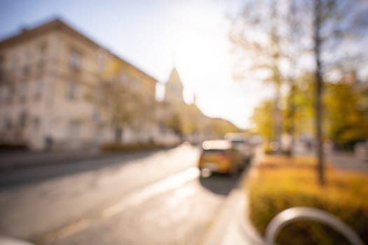 Autumn season bokeh background. Abstract city blur along the road with cars