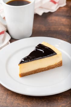 Chocolate cheesecake with brewing coffee on wooden table