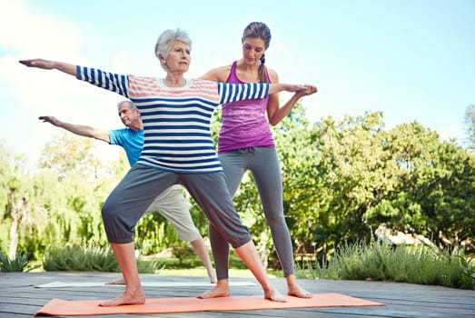 Keep in shape no matter your age. a yoga instructor guiding a senior couple in a yoga class