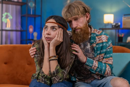 Compassion. Man supporting depressed offended woman of bad pregnancy test results. Sadness stress suffers from breaking up quarrel in work. Husband and wife hippie family marriage couple together