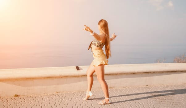 silhouette of a happy woman who dances, spins and raises her hands to the sky. A woman is enjoying a beautiful summer day.