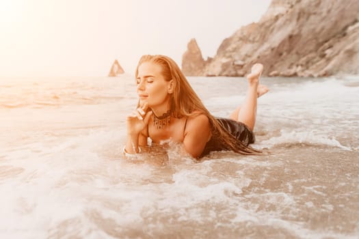 Woman travel sea. Young Happy woman in a long red dress posing on a beach near the sea on background of volcanic rocks, like in Iceland, sharing travel adventure journey