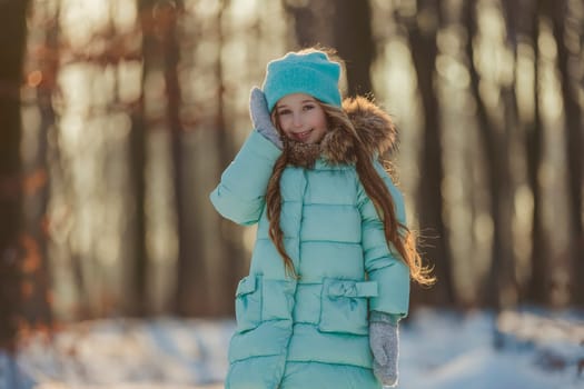 girl in turquoise clothes in a snowy forest