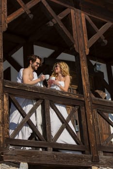 couple wrapped in blankets drinking coffee on the balcony