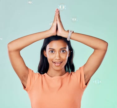 Portrait, yoga and bubbles with a woman meditating in studio on a gray background for zen or namaste. Fitness, health and wellness with an attractive young female yogi practicing meditation for peace.