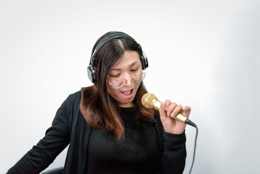 Beautiful asian woman (LGBTQ) is a singer. She enjoying sing a song or karaoke in music studio with microphone condenser and headphones for fun or voice creative