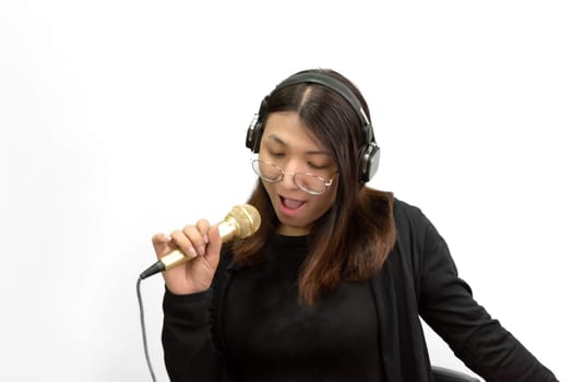 Beautiful asian woman (LGBTQ) is a singer. She enjoying sing a song or karaoke in music studio with microphone condenser and headphones for fun or voice creative