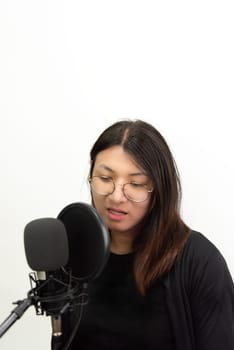 Beautiful asian woman (LGBTQ) is a singer. She enjoying sing a song or karaoke in music studio with microphone condenser and headphones for fun or voice creative