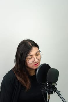 Beautiful asian woman (LGBTQ) is a singer. She enjoying sing a song or karaoke in music studio with microphone condenser and headphones for fun or voice creative