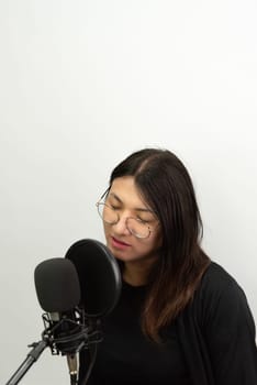 Beautiful asian woman (LGBTQ) is a singer. She enjoying sing a song or karaoke in music studio with microphone condenser and headphones for fun or voice creative