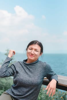 Beautiful asian woman (LGBTQ) natural makeup wear fashion relax clothes posing at sea viewpoint with happy and fun emotion in concept travel, vacation, leisure in life