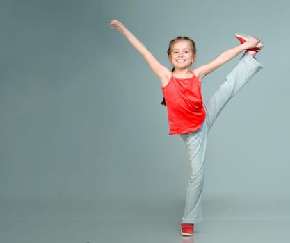 Little girl doing gymnastics exercise in studio