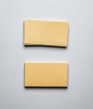 Two stacks of golden blank business cards on light background.