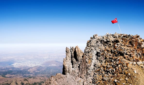 National flag of Turkey on Ercias volcano top under sun