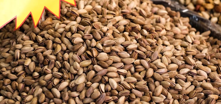 Texture of pistachios in shell lying in pile, widescreen