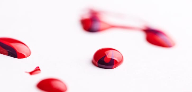 Shiny drops of red enamel isolated on white