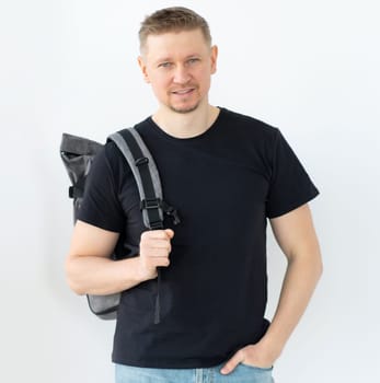 Smiling man with backpack wearing casual clothes isolated on white background