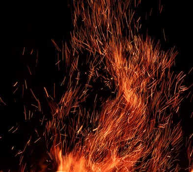 Scattering of sparks from fire on black background