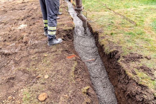 pour concrete from the mixer of the foundation of the building in the ground.