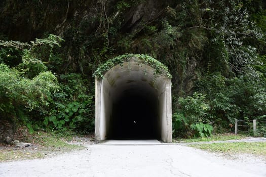 View of an entry of a long and dark tunnel in the mountains at Tianxiang, Xiulin