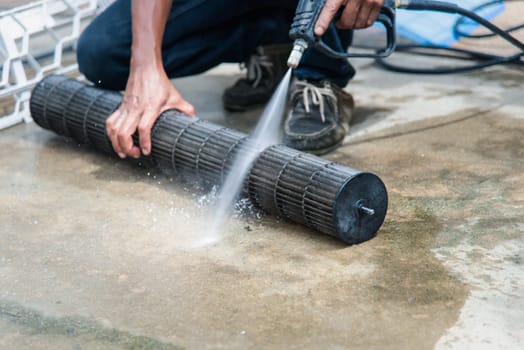 Worker to cleaning coil cooler of air conditioner by water for clean a dust on the wall in customer home when maintenance service