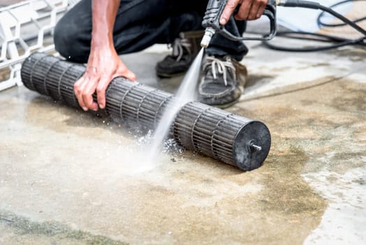 Worker to cleaning coil cooler of air conditioner by water for clean a dust on the wall in customer home when maintenance service