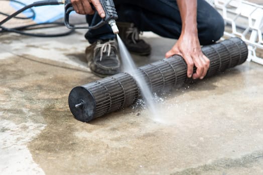 Worker to cleaning coil cooler of air conditioner by water for clean a dust on the wall in customer home when maintenance service