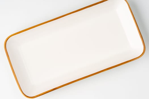 A white ceramic rectangular serving tray with an orange outline. Top view
