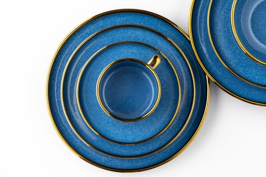 A set of blue ceramic plates and cup on a white background. Top view