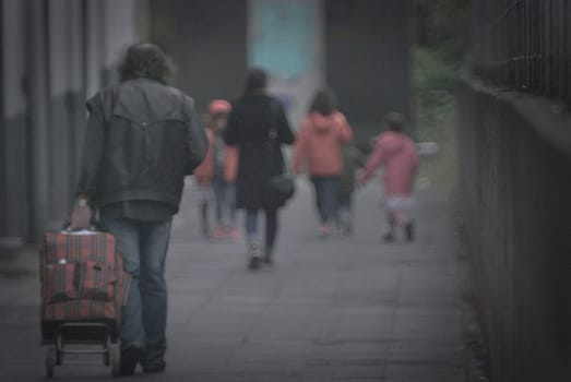 Long-haired poor man with a shopping cart in Essen, Germany