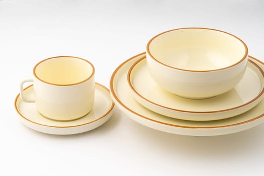 A set of white and brown ceramic plate and cup on a white background