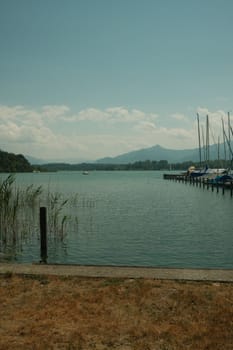 Group of sailboats by the jetty at Breitbrunn am Chiemsee in Bavaria, Germany under a bright sky