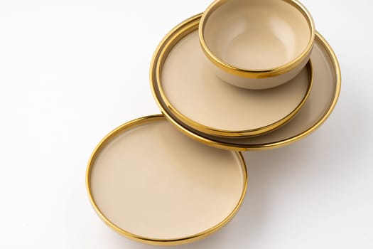 A set of light brown ceramic plate and bowl on a white background