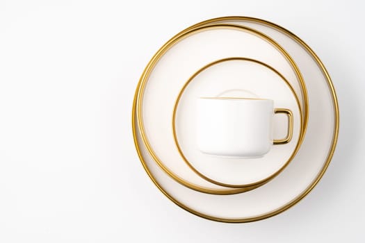A set of white and brown ceramic plate and cup on a white background. Top view