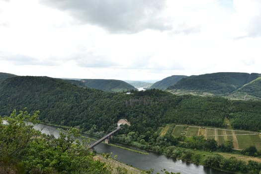 Bird's eye view of a bridge on the Moselle loop surrounded by greenery and vineyards in Germany