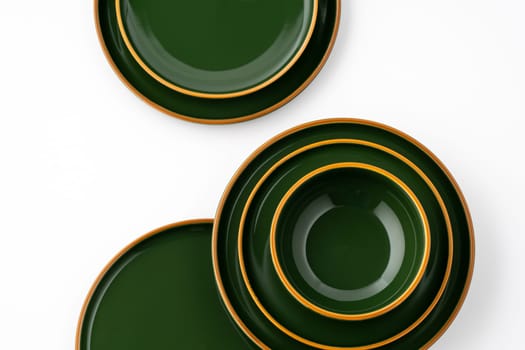 A set of green ceramic plates and bowl on a white background. Top view