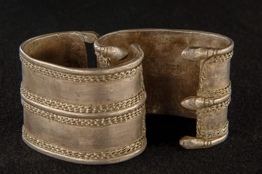 An antique bracelet with engraving isolated on a black background