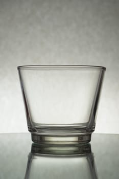 A vertical shot of an empty glass on a grey background