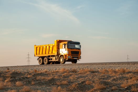 An orange dumper truck in an construction area