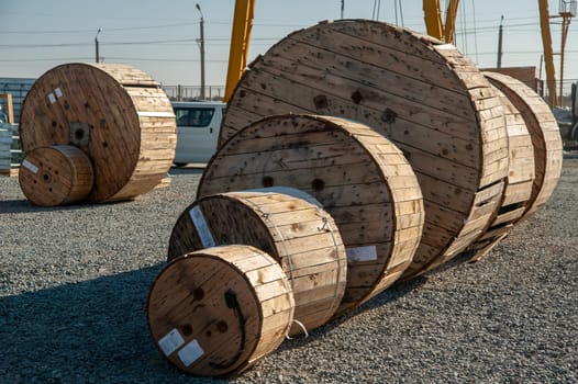 A closeup of large industrial wooden bobbins with cable on a construction site