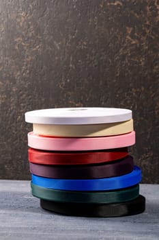 A vertical shot of a stack of colored fabric rolls for fashion design