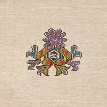 A closeup shot of an abstract colorful embroidery design on a beige cloth