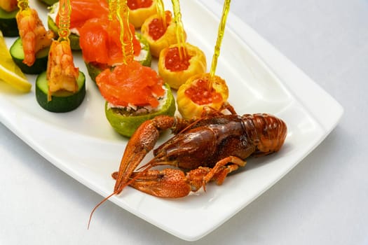 A closeup shot of cooked cancer with appetizers on skewers on the plate