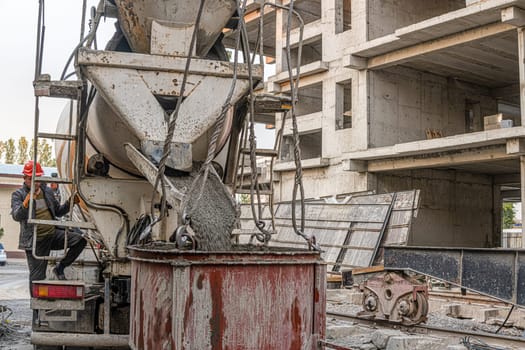 Worker on a construction site building infrastructure with machinery and tools. Pouring concrete