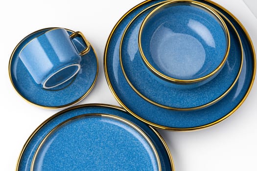 A set of blue ceramic plates and cup on a white background