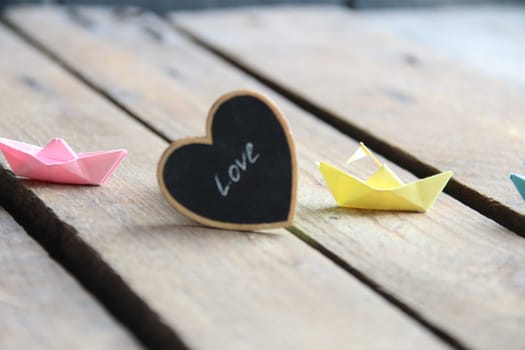 Love idea. Beautiful paper boats on a vintage wooden background.