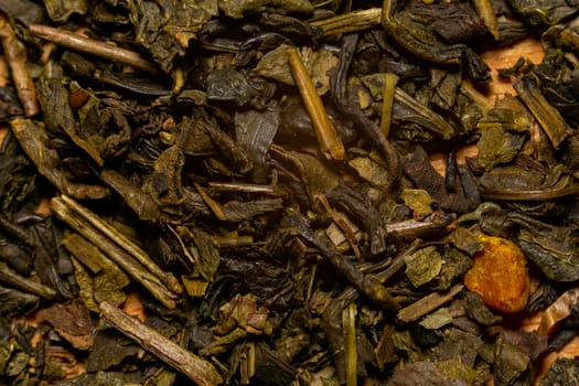 A mixture of dry green large-leaf tea with soursop. Extreme close-up macro view